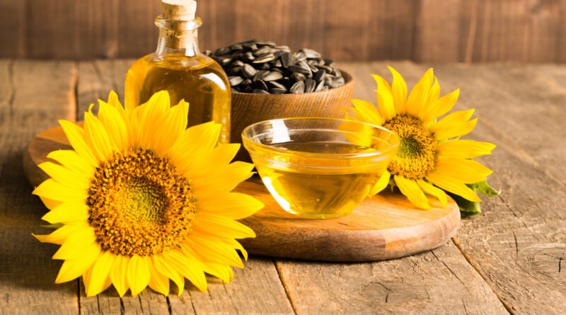 Aceite de girasol con semillas sobre fondo de madera, ilustra la denuncia por adulteración con soja