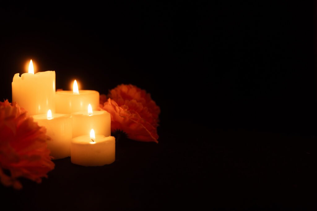 Velas encendidas entre flores que ilustran el aniversario de la AMIA y el reclamo de memoria