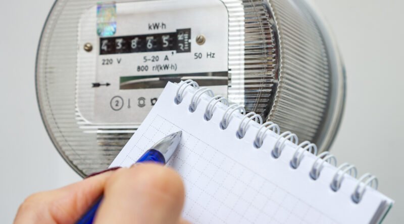 Aumentos de agosto: mano anotando la lectura de un medidor de electricidad