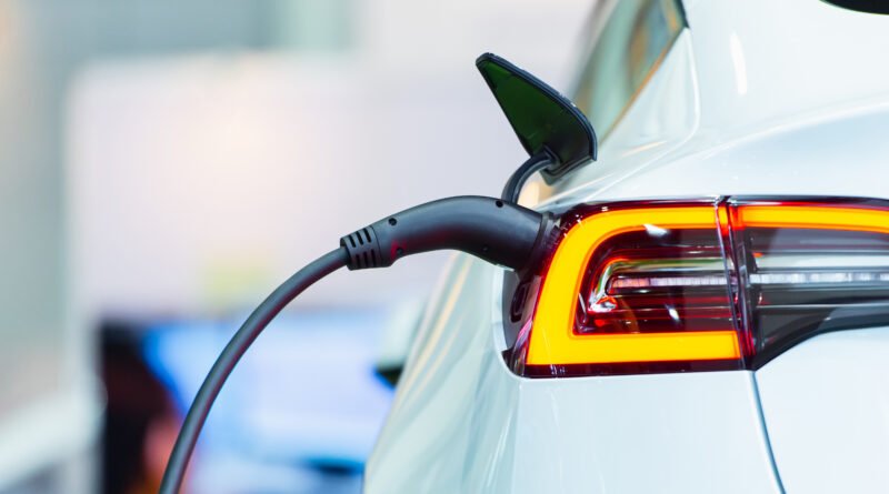 autos híbridos y eléctricos: auto híbrido conectado a un cargador en una estación