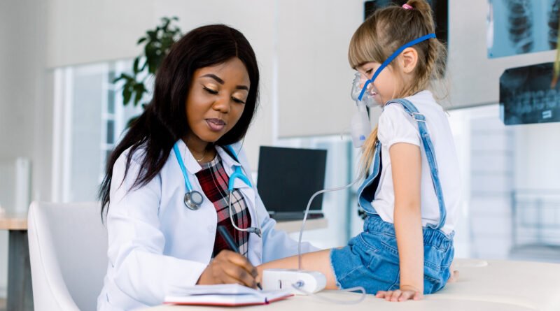 bronquiolitis en Salta: profesional de salud asistiendo a una niña con máscara de nebulizador