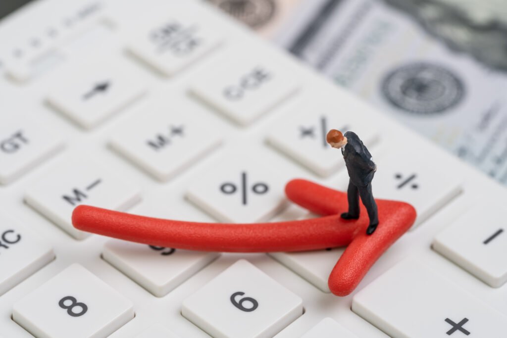 Déficit fiscal: flecha roja en baja sobre calculadora y dólares