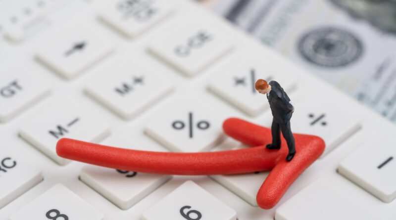 Déficit fiscal: flecha roja en baja sobre calculadora y dólares