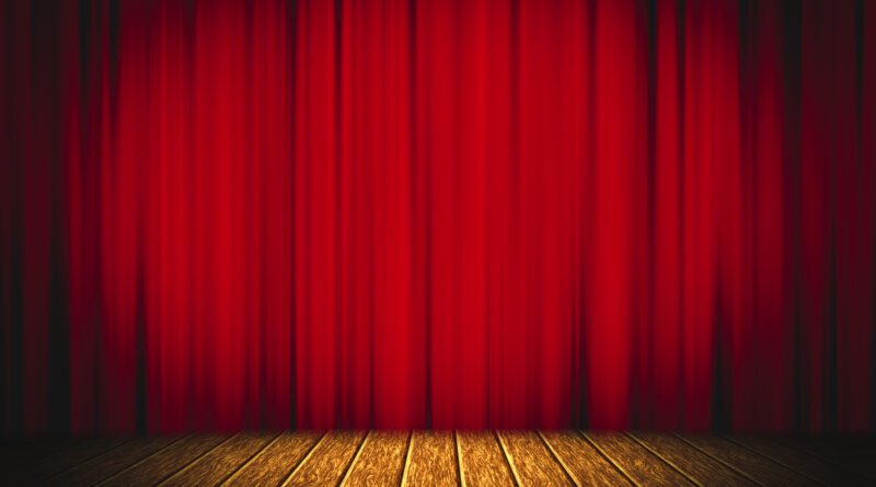 Embarazo de Mica Riera: escenario de teatro con telón rojo y piso de madera