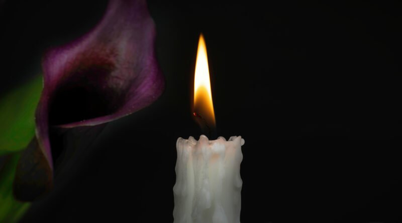 Vela encendida y flor violeta que acompañan la nota sobre el femicidio en Junín
