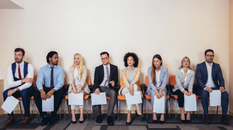 feria de empleo: grupo de postulantes esperando para una entrevista de trabajo
