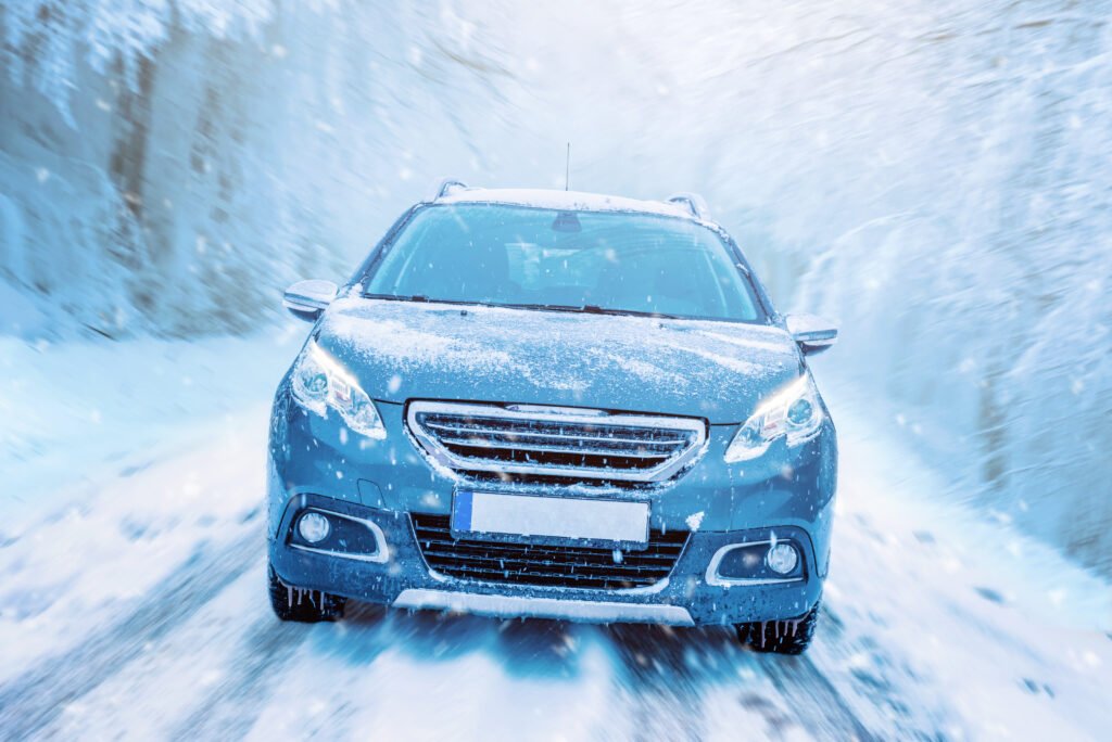 Auto andando por una ruta nevada, ilustra las escapadas del fin de semana largo del 9 de Julio
