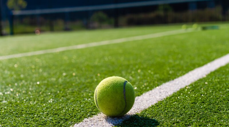 Raqueta sobre una cancha de césped que ilustra la final de Wimbledon ganada por Noskova