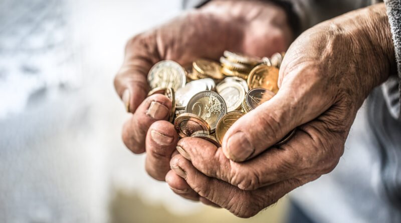 jubilaciones de agosto: manos de un jubilado sosteniendo monedas y billetes