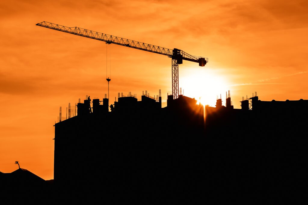 Grúa de construcción a contraluz en un atardecer, homenaje a Luis Margani, protagonista de Mundo Grúa
