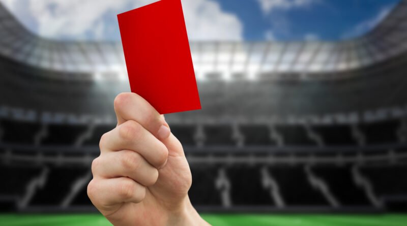 Mano mostrando una tarjeta roja en un estadio, ilustra el escándalo por los insultos racistas a Mbappé