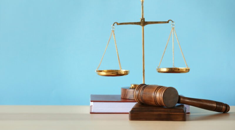 Mila Yankelevich: balanza y martillo de la justicia sobre una mesa de madera