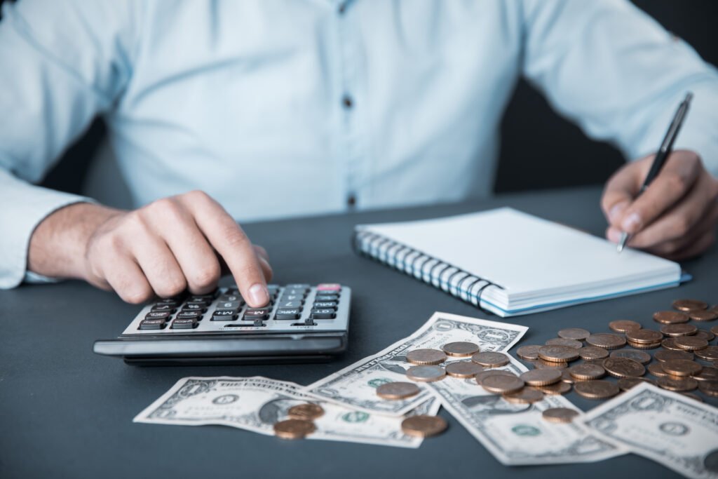 paritarias de julio: manos con billetes, calculadora y anotador que ilustran el ajuste de salarios