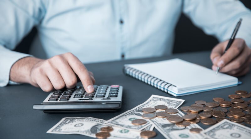 paritarias de julio: manos con billetes, calculadora y anotador que ilustran el ajuste de salarios