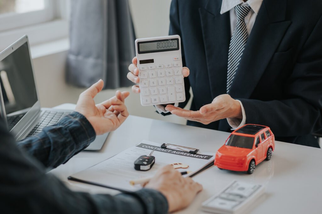 Calculadora junto a un auto que ilustra los precios de autos 0km frente a la inflación