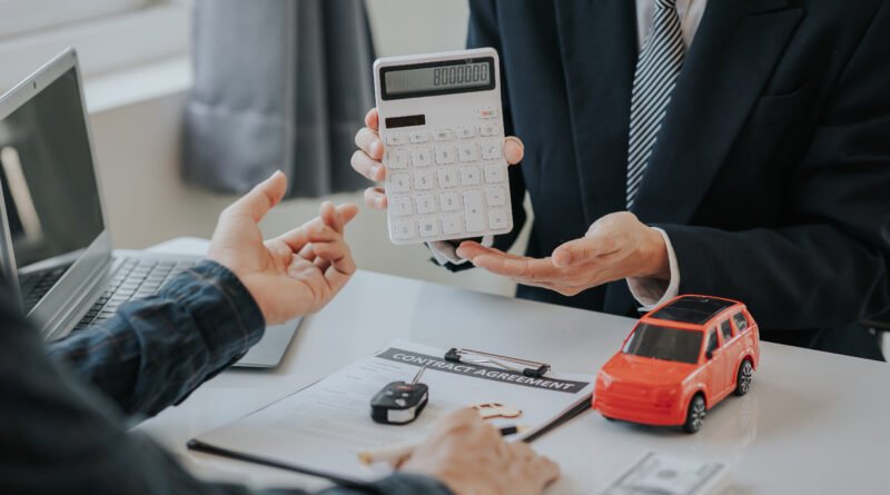 Calculadora junto a un auto que ilustra los precios de autos 0km frente a la inflación