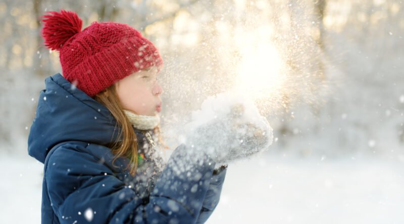 Nena abrigada divirtiéndose en un parque nevado, ilustra las vacaciones de invierno 2026