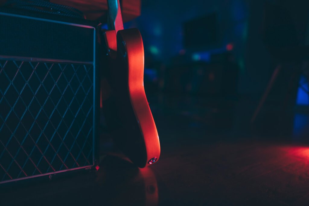 Walter Ortiz: silueta de guitarra eléctrica y amplificador en un ambiente oscuro, homenaje al metal