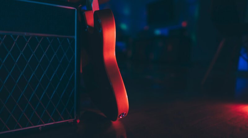 Walter Ortiz: silueta de guitarra eléctrica y amplificador en un ambiente oscuro, homenaje al metal