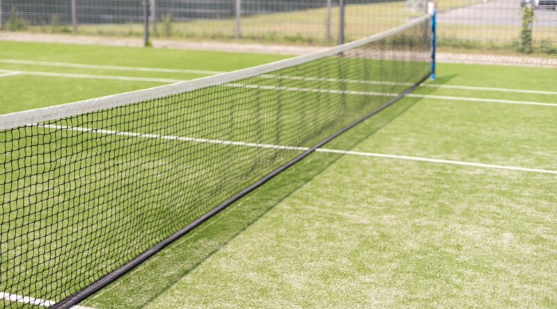Red y cancha de césped de tenis, ilustran la final femenina de Wimbledon entre Muchova y Noskova