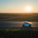 Aion V: auto eléctrico moderno en una ruta al atardecer