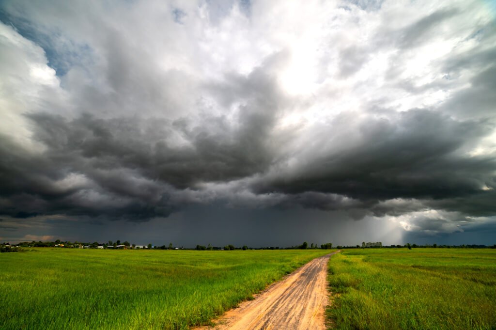 alerta por tormentas: nubes de tormenta y lluvia sobre un camino rural