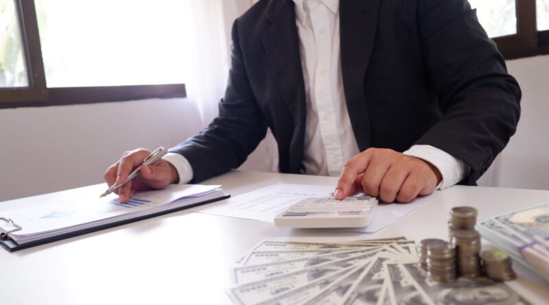 aumento a estatales: calculadora, monedas y dinero sobre un escritorio