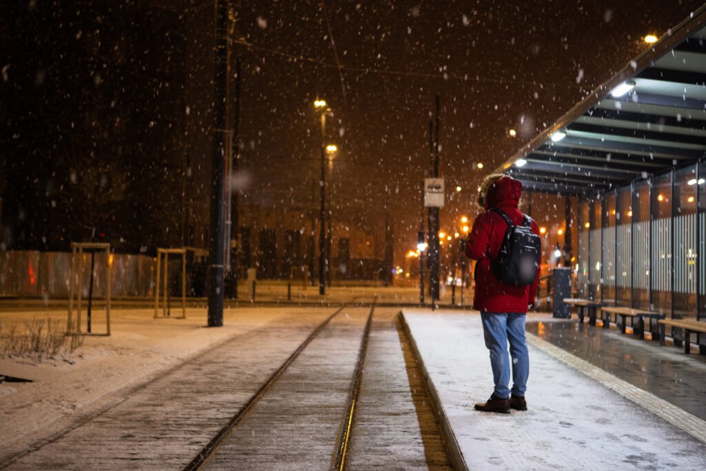 aumentos de agosto: persona esperando el colectivo en una parada en invierno