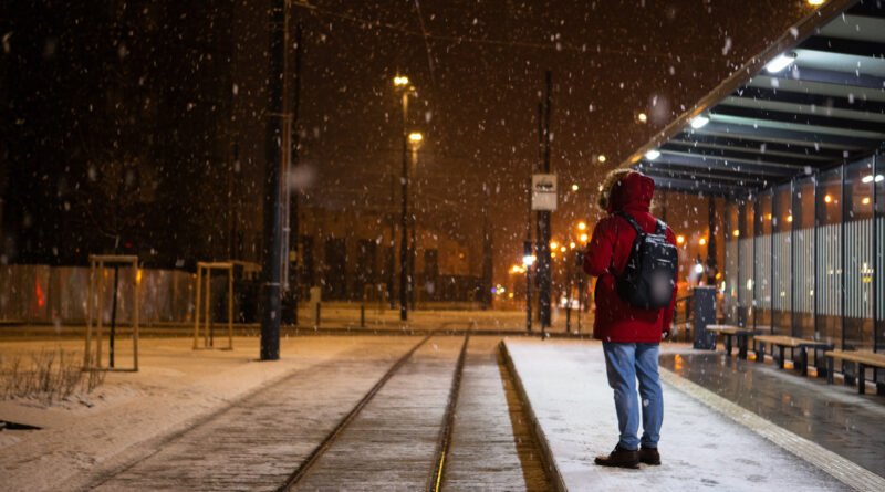 aumentos de agosto: persona esperando el colectivo en una parada en invierno