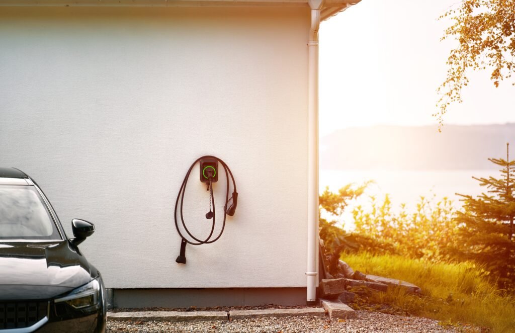autos 0km más baratos: cargador de pared para auto eléctrico en un garaje