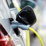 autos 0km más baratos: auto eléctrico cargando con un cable de energía