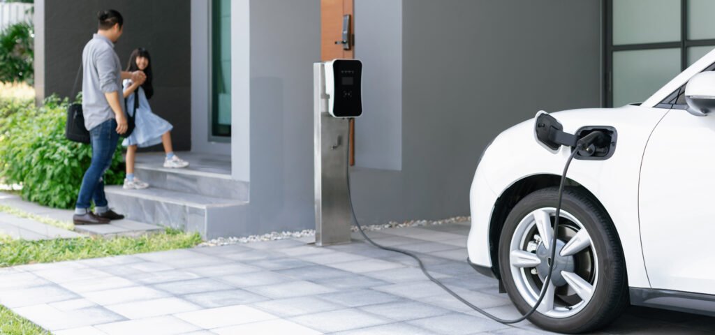 Autos 0km más baratos: un auto eléctrico cargando en una casa