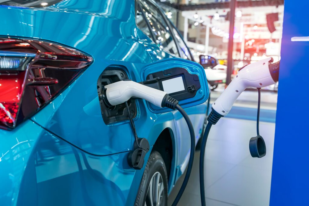autos chinos: un auto eléctrico cargando en una estación de carga en un estacionamiento