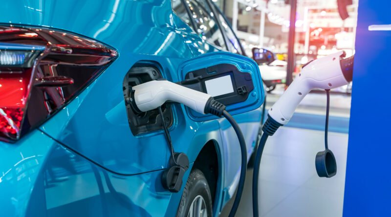 autos chinos: un auto eléctrico cargando en una estación de carga en un estacionamiento