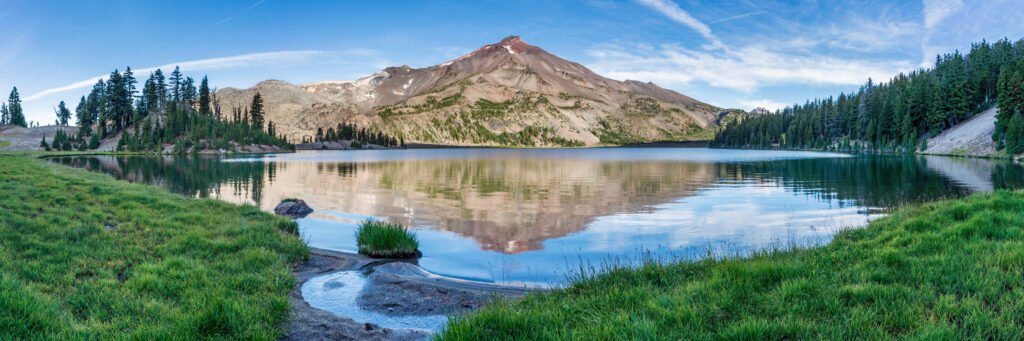 camioneta en un lago: lago de montaña de aguas calmas y cumbres nevadas