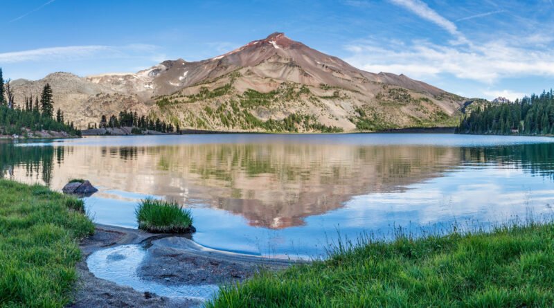 camioneta en un lago: lago de montaña de aguas calmas y cumbres nevadas