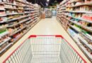 consumo masivo: góndola de supermercado con un carrito de compras