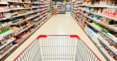 consumo masivo: góndola de supermercado con un carrito de compras