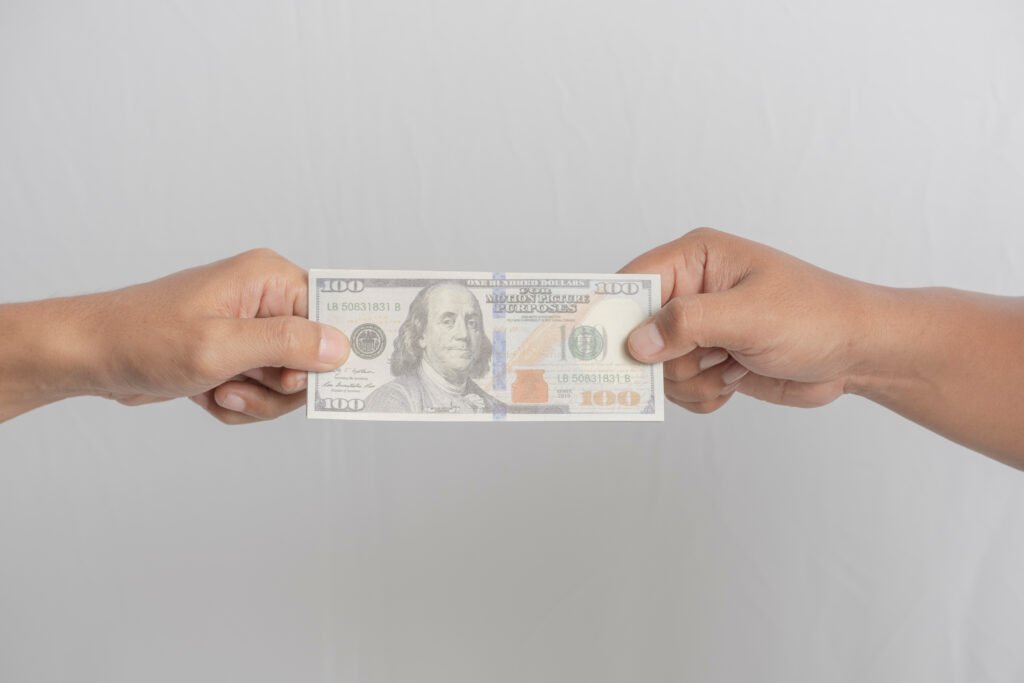 crédito en dólares: intercambio de billetes de dólares entre dos personas