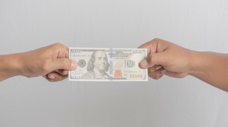 crédito en dólares: intercambio de billetes de dólares entre dos personas