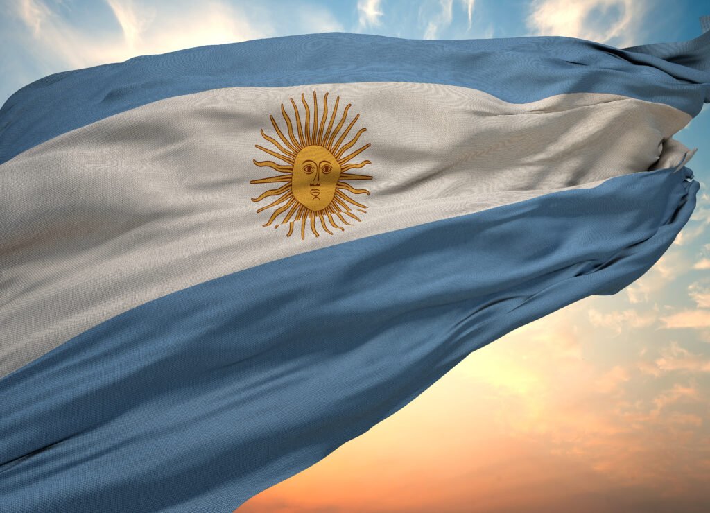 cumbre del peronismo: bandera argentina flameando contra el cielo azul