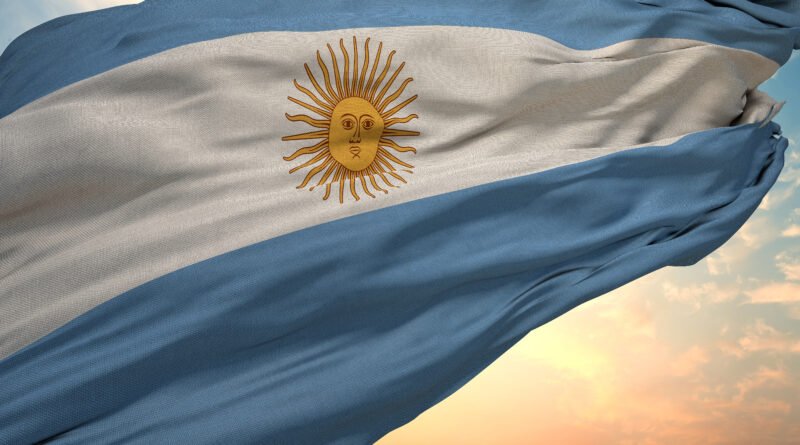 cumbre del peronismo: bandera argentina flameando contra el cielo azul