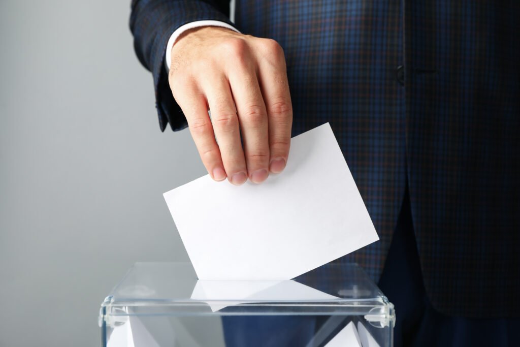 desdoblamiento en Buenos Aires: urna electoral con un sobre de votación