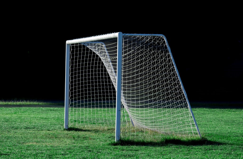 Dibu Martínez: arco de fútbol vacío en un estadio de césped verde