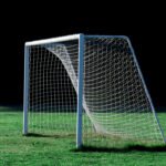 Dibu Martínez: arco de fútbol vacío en un estadio de césped verde