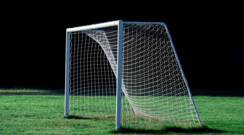 Dibu Martínez: arco de fútbol vacío en un estadio de césped verde