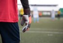 Dibu Martínez: arquero de fútbol atajando un balón frente al arco