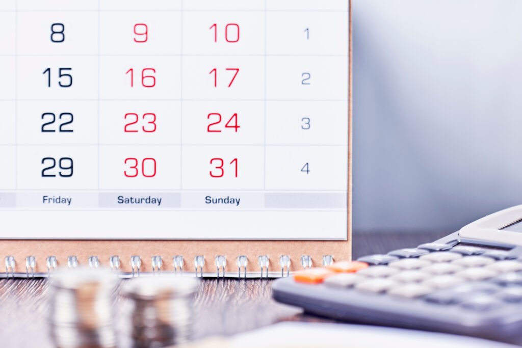 dólar a fin de año: calendario, calculadora y monedas sobre un escritorio