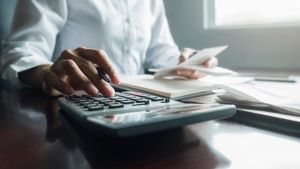 inflación de julio: una persona calcula gastos con billetes y calculadora