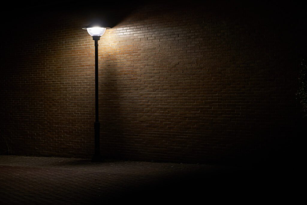 Inseguridad nocturna: farola solitaria iluminando una calle oscura de noche